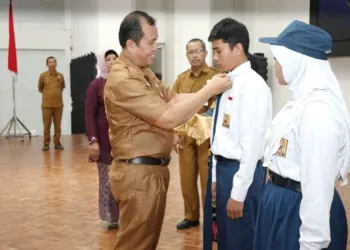 Staf Ahli Bidang Pembangunan, Kemasyarakatan, dan SDM Sekretariat Daerah Kota Bontang, Asdar Ibrahim melepas atribut siswa SMPN 6 Bontang dalam momen perpisahan dan pelepasan.